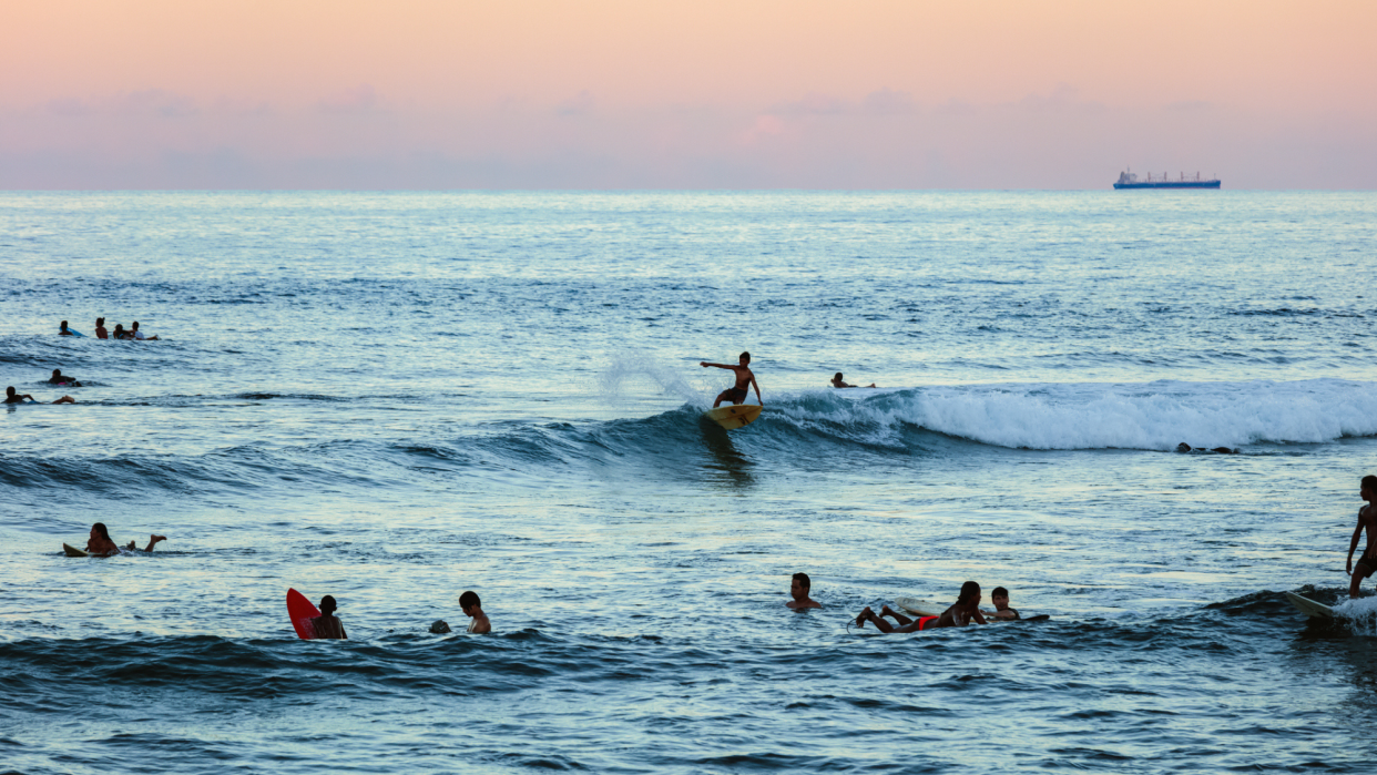  Surfers catch waves on the coastline of Siargao. 