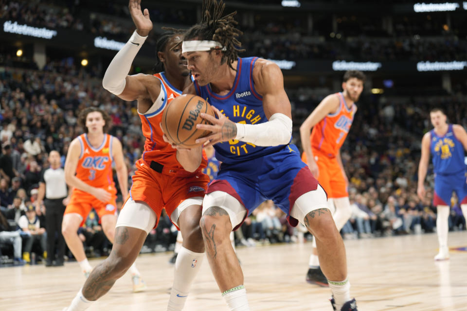 Denver Nuggets forward Aaron Gordon, front right, drives to the basket as Oklahoma City Thunder forward Jalen Williams, front left, defends in the first half of an NBA basketball game Saturday, Dec. 16, 2023, in Denver. (AP Photo/David Zalubowski)