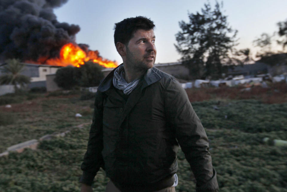 Chris Hondros stands in front of a burning building while on assignment on April 18, 2011, in Misrata, Libya. (Photo: Katie Orlinsky via Getty Images)