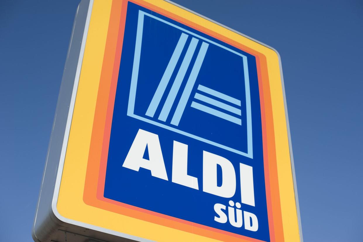 Closeup of an Aldi Süd store sign in Obernburg, Germany, slightly looking up to it, against a blue sky