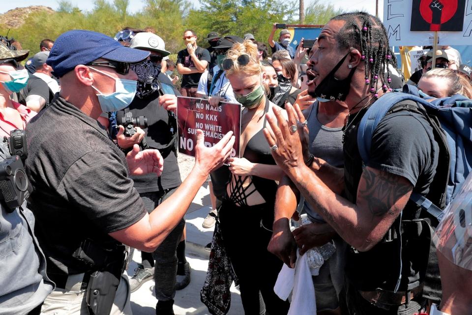 A protester argues with a Phoenix police officer outside Dream City Church   in Phoenix as President Donald Trump speaks inside.  