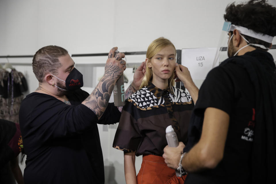 A model gets her make-up done in the backstage prior to the start of the Shi.RT women's Spring-Summer 2021 fashion show, in Milan, Italy, Sunday, Sept. 27, 2020. (AP Photo/Luca Bruno).