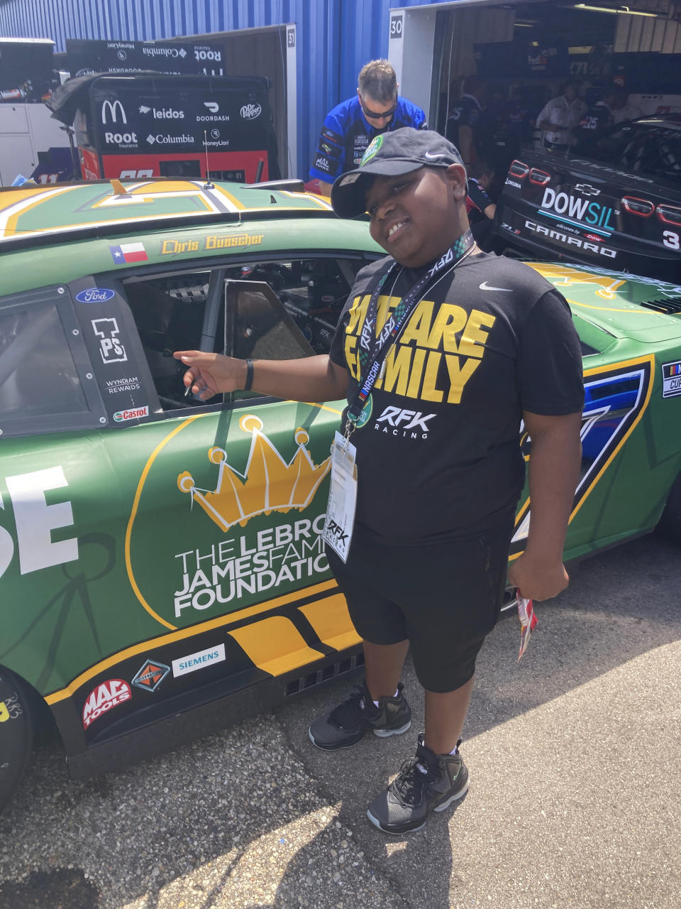 James Bromsey III, a sixth-grader at LeBron James' I Promise School in Akron, Ohio, looks at NASCAR driver Chris Buescher's car, Sunday, Aug. 7, 2022 in Brooklyn, Mich. Bromsey was given an all-access tour of Michigan International Speedway in Brooklyn, Mich., on Sunday. Chris Buescher’s No. 17 Ford had a paint job that highlighted the LeBron James Family Foundation. (AP Photo/Larry Lage)