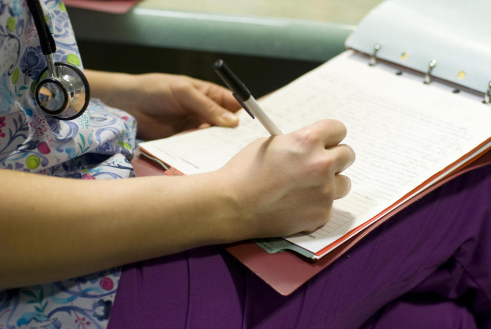 A nurse writing on a chart