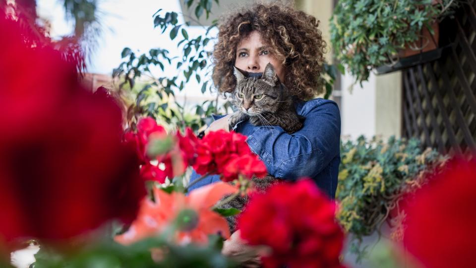 Woman stood on balcony holding her cat