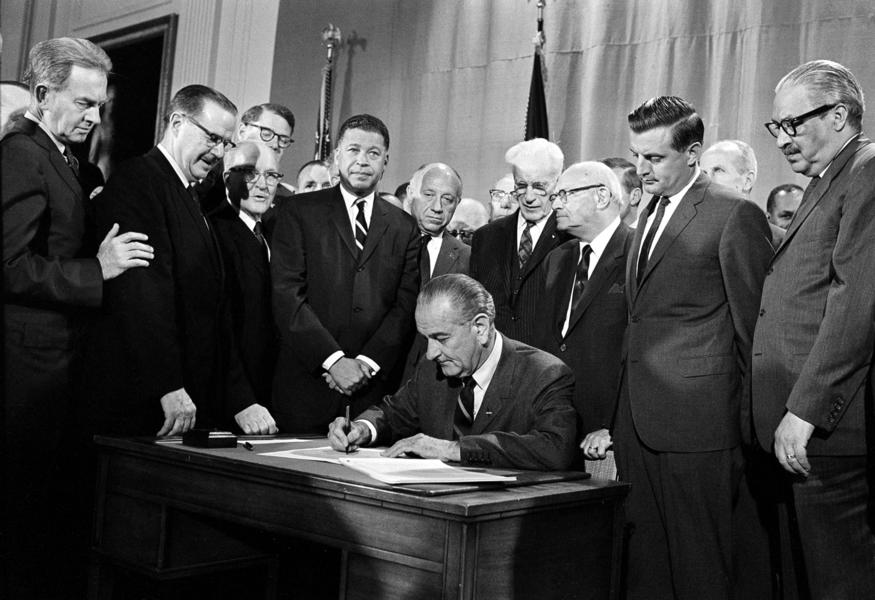 Minnesota Sen. Walter Mondale (second from right) looks on as President Lyndon B. Johnson signs the Fair Housing Act in the White House on April 11, 1968.  Next to Mondale is Supreme Court Justice Thurgood Marshall.