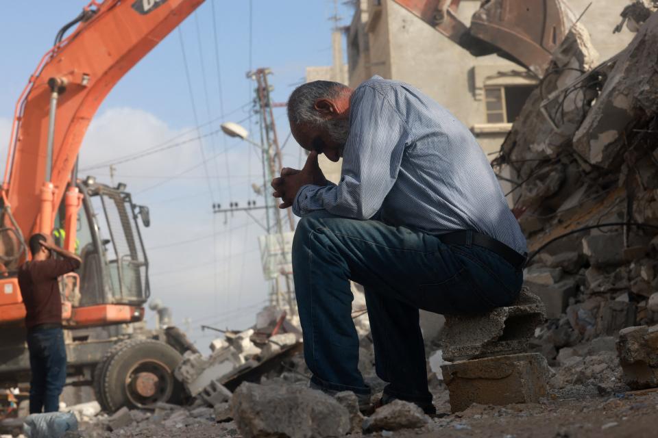 A Palestinian man wait for news of his daughter as rescue workers search for survivors under the rubble of a building hit in an overnight Israeli bombing in Rafah, in the southern Gaza Strip, on April 21.