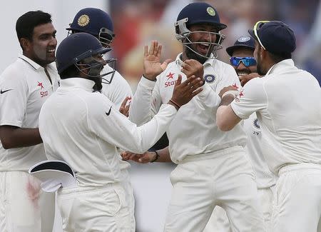 India's Cheteshwar Pujara (C) celebrates with captain Virat Kohli (R), Amit Mishra (2nd R), Rohit Sharma (2nd L) and Ravichandran Ashwin (L) after taking the catch to dismiss Sri Lanka's Lahiru Thirimanne (not pictured) during the fifth day of their second test cricket match in Colombo August 24, 2015. REUTERS/Dinuka Liyanawatte