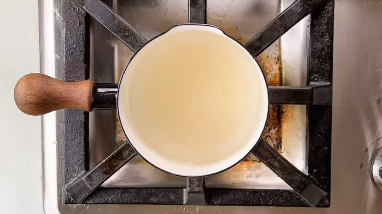 Water and sugar cooking in saucepan on stovetop