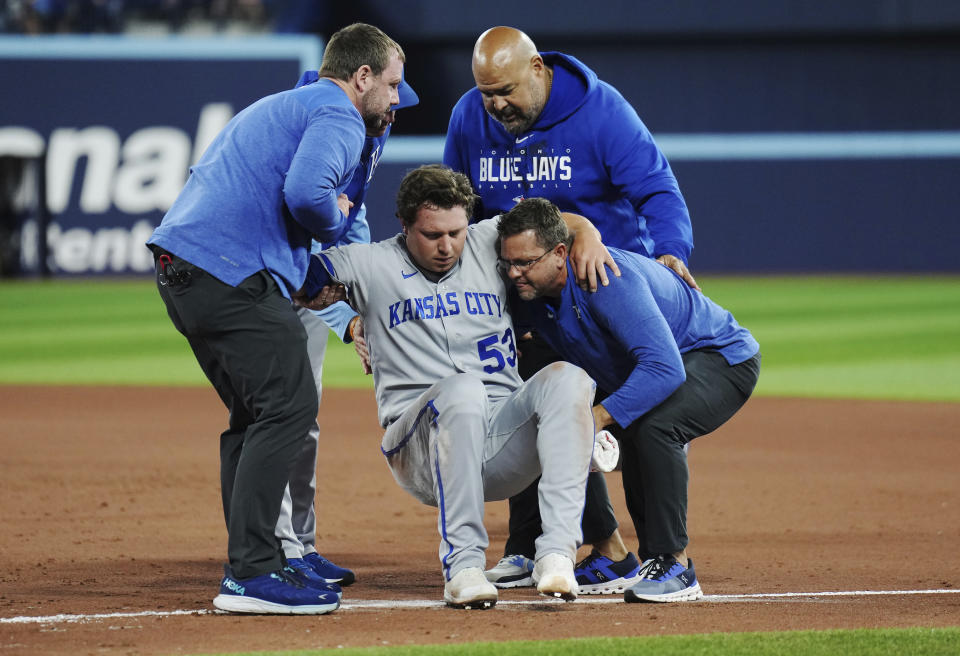 Kansas City Royals relief pitcher Austin Cox is helped off the field by medical staff after an injury during the seventh inning of the team's baseball game against the Toronto Blue Jays on Friday, Sept. 8, 2023, in Toronto. (Nathan Denette/The Canadian Press via AP)