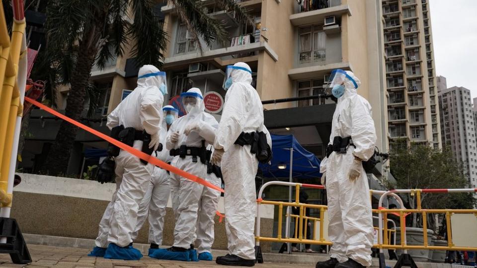 2022/01/23: Police officers in protective gear guard at the lockdown area in Kwai Chung Estate. Beginning with the Yat Kwai House at Kwai Chung Estate,