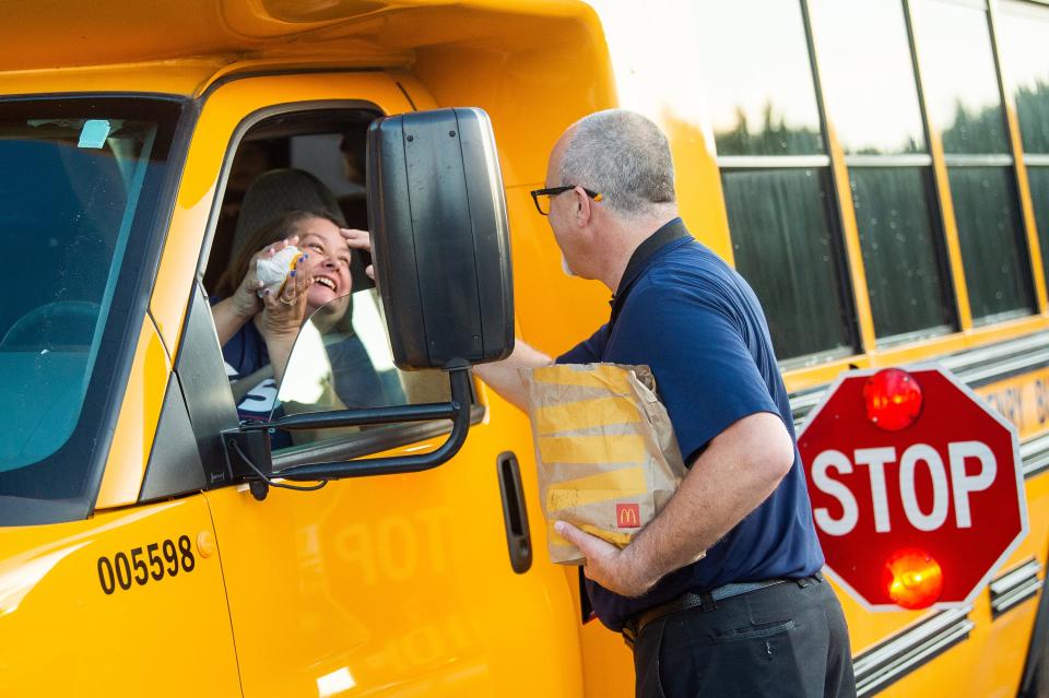 Breakfast sandwiches are handed out to bus drivers at the new Mill Creek Elementary School. The district is low on drivers.