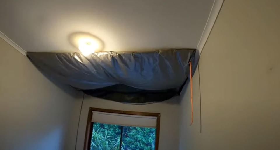 Bedroom ceiling with black tarp after it collapsed. 