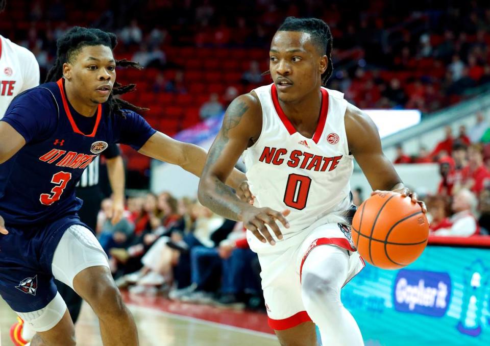 N.C. State’s DJ Horne (0) drives around UT Martin’s Jordan Sears (3) during the first half of N.C. State’s game against UT Martin at PNC Arena in Raleigh, N.C., Tuesday, Dec. 12, 2023.