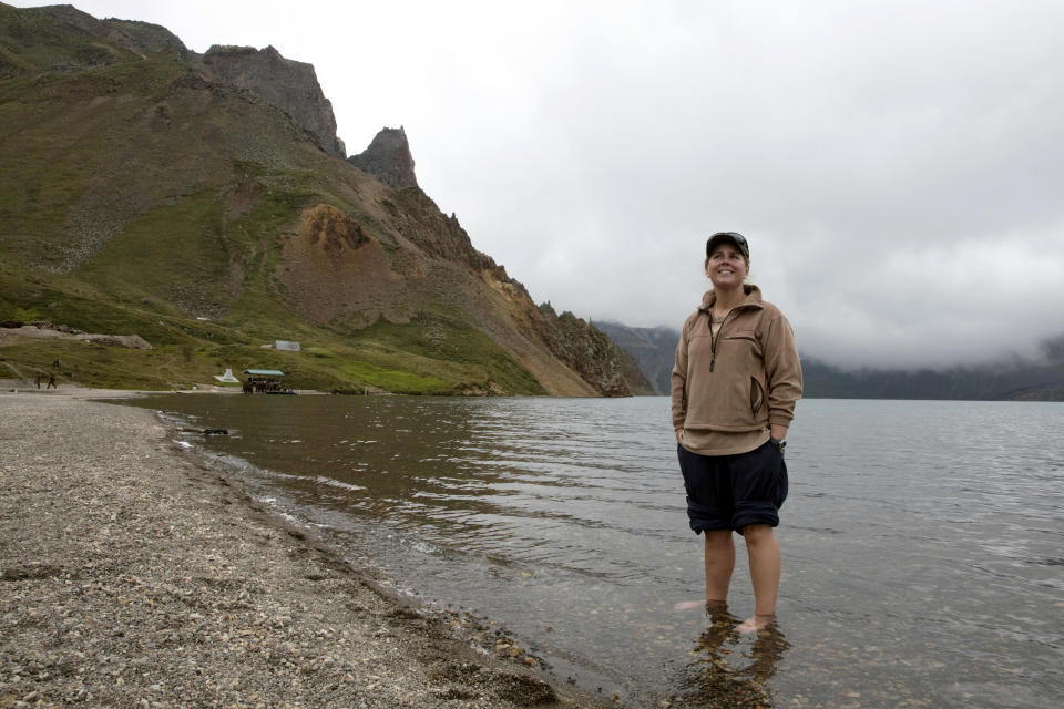 In this Saturday, Aug. 18, 2018, photo, Sinead of Australia stands in the cool water of Lake Chon during a hike arranged by Roger Shepherd of Hike Korea on Mount Paektu in North Korea. Hoping to open up a side of North Korea rarely seen by outsiders, Shepherd, a New Zealander who has extensive experience climbing the mountains of North and South Korea is leading the first group of foreign tourists allowed to trek off road and camp out under the stars on Mount Paektu, a huge volcano that straddles the border that separates China and North Korea. (AP Photo/Ng Han Guan)