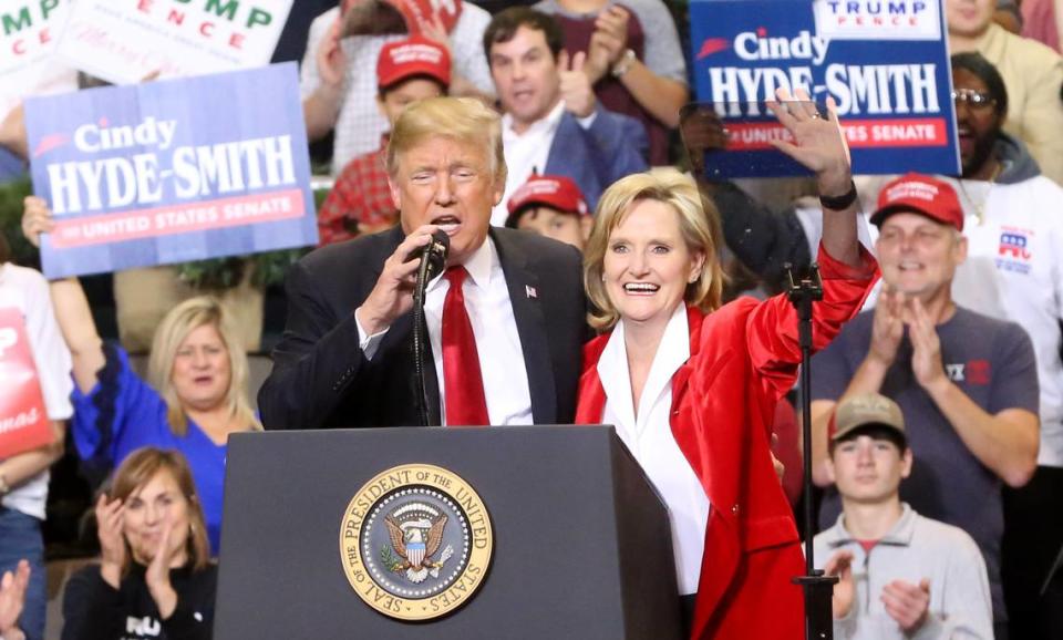 President Donald Trump speaks as Sen. Cindy Hyde-Smith waves to the crowd at the Mississippi Coast Coliseum in Biloxi on Monday, Nov. 26, 2018.