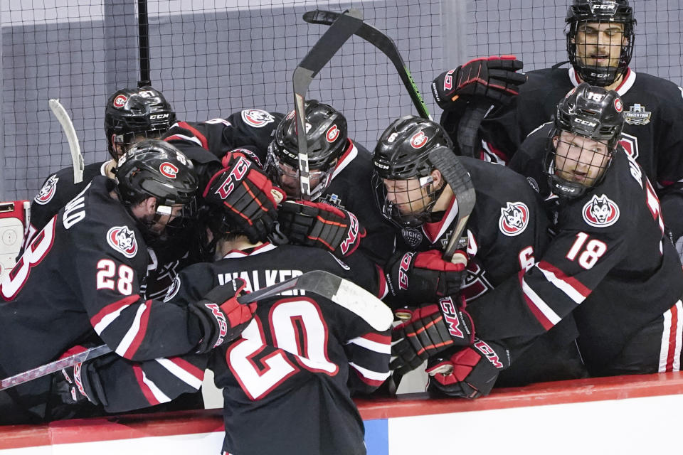 St. Cloud State's Nolan Walker (20) is greeted by teammates after scoring against Minnesota State to break a tie with less than a minute left in an NCAA men's Frozen Four hockey semifinal in Pittsburgh, Thursday, April 8, 2021. St. Cloud State won 5-4 to advance to the championship game Saturday. (AP Photo/Keith Srakocic)