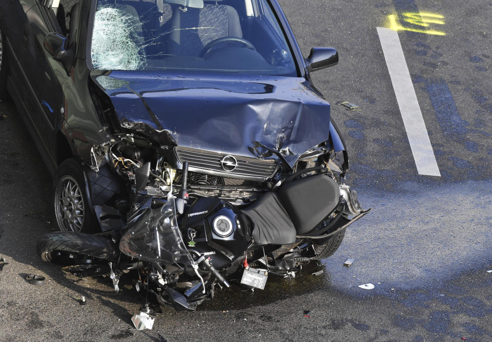 A car and a motorcycle stand on the city motorway A100 after an accident in Berlin, Germany, Wednesday, Aug. 19, 2020. The city's highway was still shut down after a series of traffic accidents that were allegedly all caused by one man. (Paul Zinken/dpa via AP)