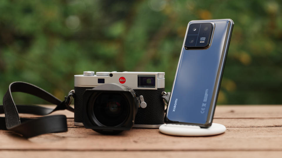 Leica M11 camera next to the Xiaomi 13 Pro on a wooden table.