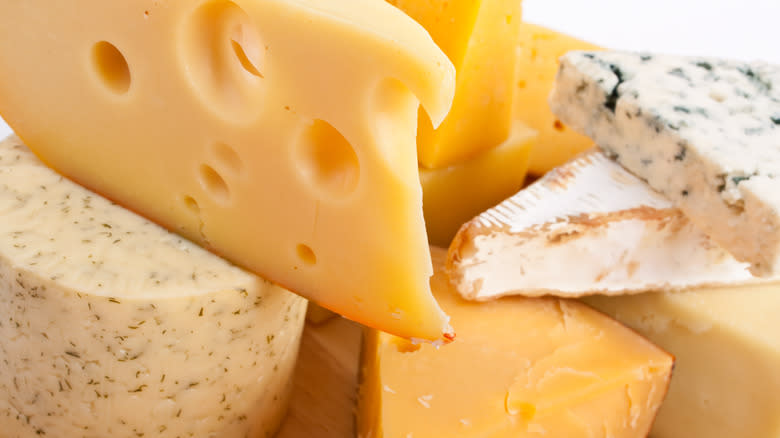 Cheese varieties stacked on background