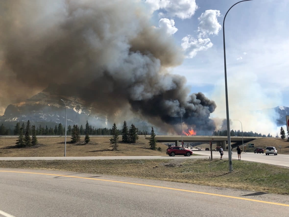 Smoke and flames are seen rising from a fire that started as a prescribed burn near Banff, Alta., on Wednesday afternoon. The fire is now classified as under control. (Submitted by Zixi Chen - image credit)