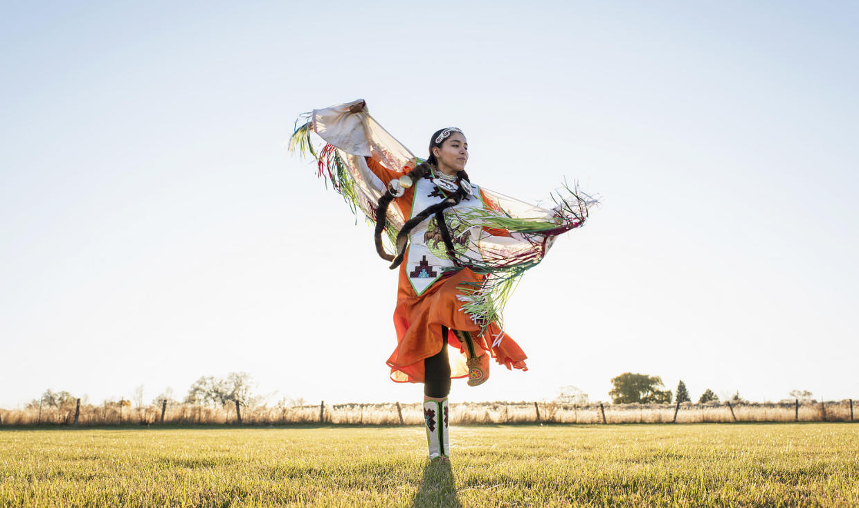 Young Native American woman dancing in traditional dress. (Tony Anderson / Getty Images)