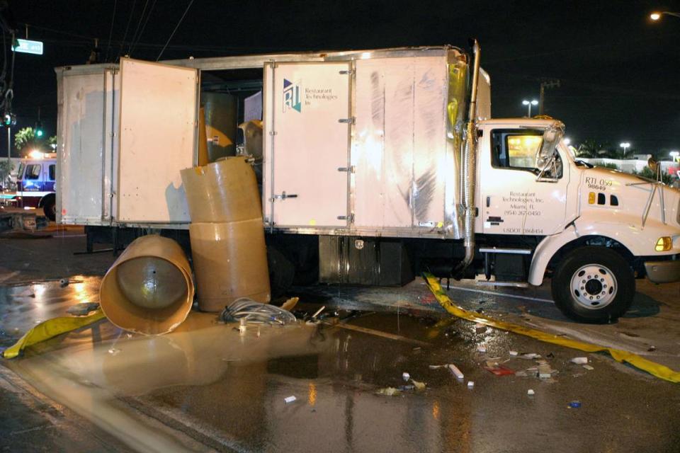 Cuadrillas limpian los barriles vacíos después de que un camión derramara una carga de aceite de cocina de canola en 2004 sobre Commercial Boulevard, al este de Dixie Highway, en el Condado Broward