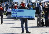 Man displays a poster during a protest against the government's restrictions in Konstanz