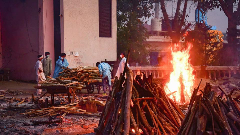 Angehörige eines an den Folgen des Coronavirus Verstorbenenen sammeln in Neu Delhi Holz für die Einäscherung.