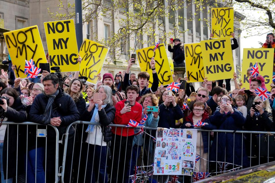 Protesters hold signs reading 