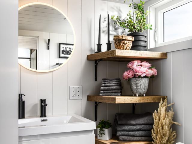 a bathroom with a vanity, shelves, and sink