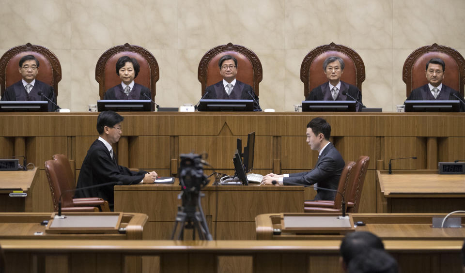 South Korean Chief Justice of the Supreme Court Kim Myeongsu, center, sits with other justices upon their arrival at the Supreme Court in Seoul, South Korea, Thursday, Nov. 1, 2018. South Korea's top court has ruled that people can legally reject mandatory military service on conscientious or religious grounds and must not be punished. (Yun Dong-jin/Yonhap via AP)