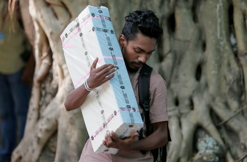 An election official carries ballot papers into a bus from a distribution center to polling stations, ahead of country's presidential election scheduled on November 16, in Colombo