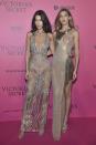 <p>The model sisters hid nothing in sparkly metallic gowns by Julien MacDonald and Atelier Versace. <i>[Photo: Getty]</i> </p>