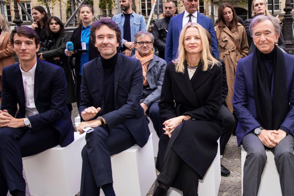 Delphine Arnault with her brothers and Bernard Arnault sit front row at a fashion show