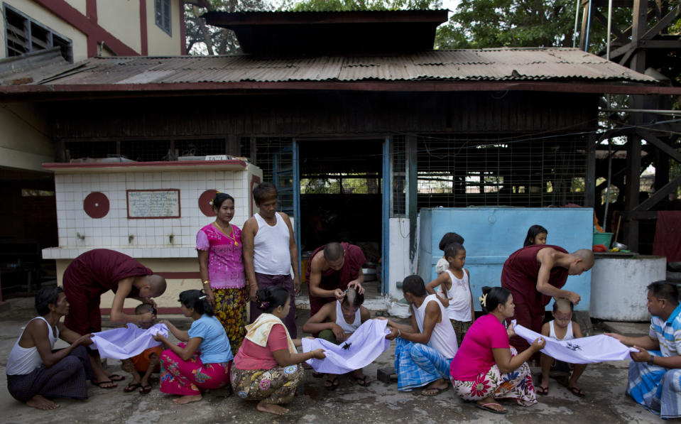 In this April 8, 2014 photo, Buddhist monks shave the heads of men and boys during an ordination ceremony at a Buddhist monastery in suburbs of Yangon, Myanmar. Though most boys only remain monks for a few days, ordination is seen as a right of passage in this predominantly Buddhist nation of 60 million. In addition to learning the basic tenants of their faith, it serves as a sort of spiritual credit for their parents, helping emancipate them from a viscous cycle of rebirth and death. (AP Photo/Gemunu Amarasinghe)