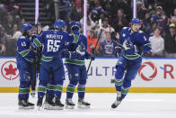 Vancouver Canucks' Nikita Zadorov, right, turns to skate to the bench after celebrating his goal against the Montreal Canadiens during the first period of an NHL hockey game in Vancouver, British Columbia, Thursday, March 21, 2024. (Darryl Dyck/The Canadian Press via AP)