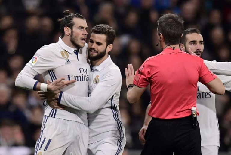 Real Madrid's forward Gareth Bale (L) argues with the referee as Real Madrid's defender Nacho Fernandez (2ndL) tries to stop on March 1, 2017