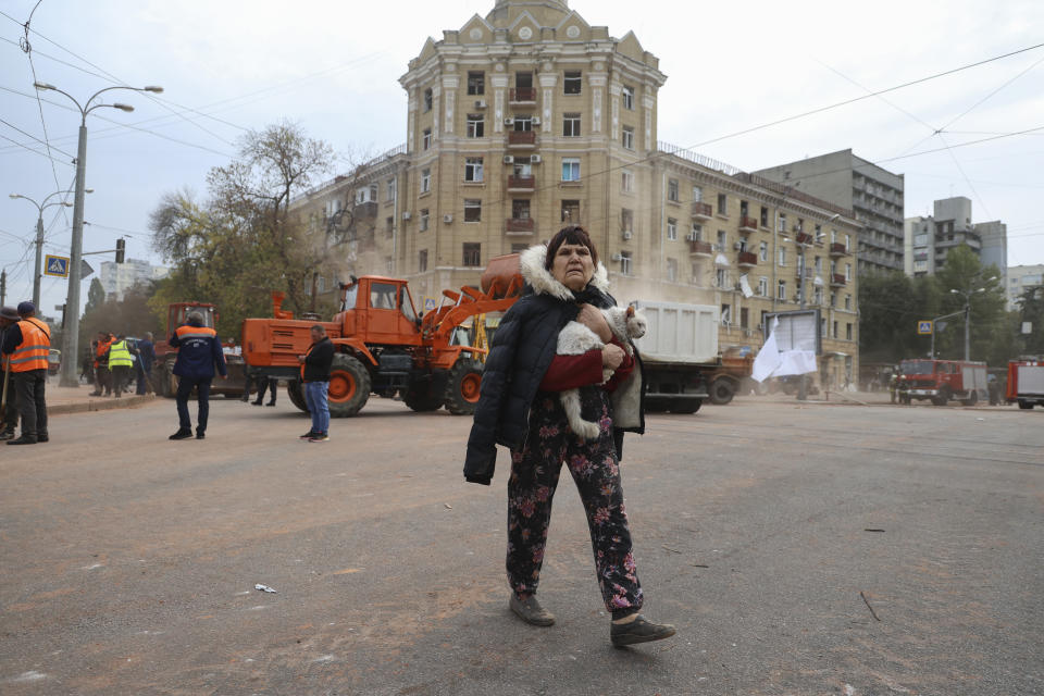 A local resident carries a cat as she passes by an apartment building damaged in the Russian rocket attack in central Kharkiv, Friday, Oct. 6, 2023. (AP Photo/Alex Babenko)