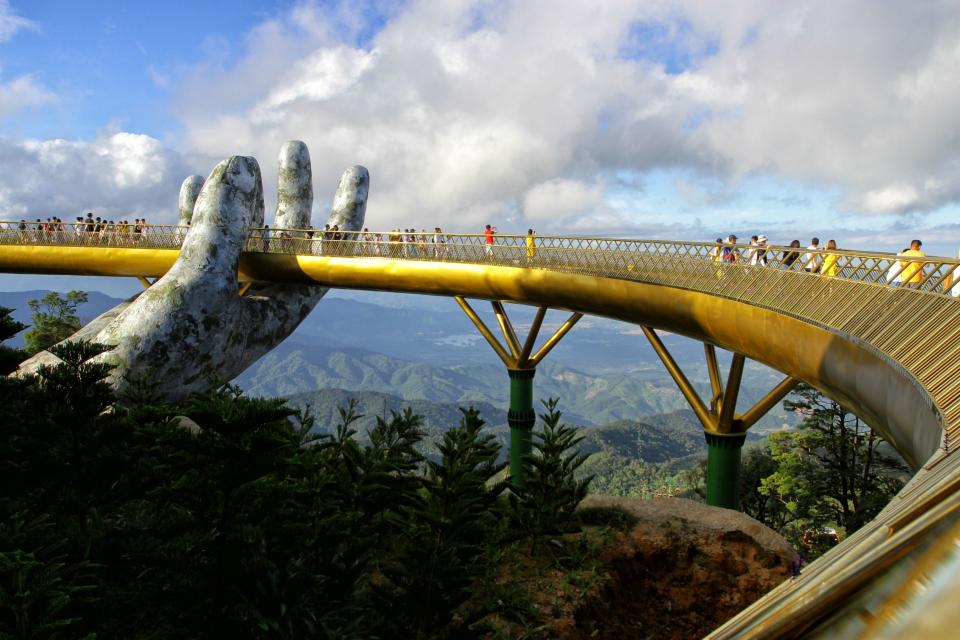 In this photograph taken on July 31, 2018, visitors walk along the 150-meter long Cau Vang "Golden Bridge" in the Ba Na Hills near Danang, Vietnam.