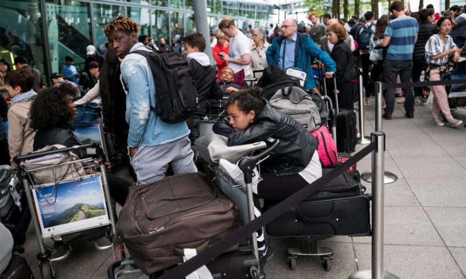 People queue with their luggage outside Heathrow Terminal 5 on Sunday.