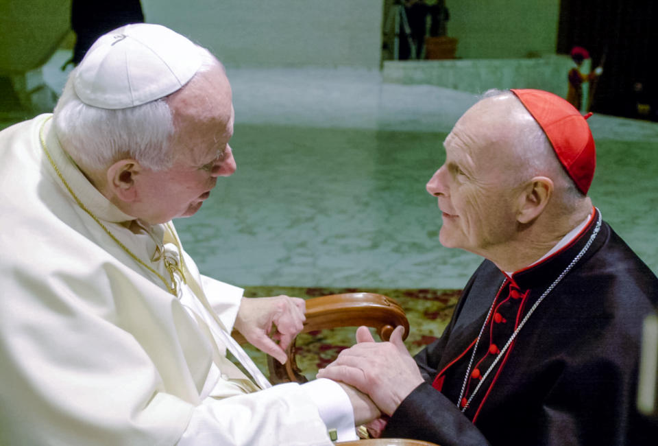 FILE - In this Feb. 23, 2001 file photo, U.S. Cardinal Theodore Edgar McCarrick, archbishop of Washington, D.C., shakes hands with Pope John Paul II during the General Audience with the newly appointed cardinals in the Paul VI hall at the Vatican. Pope Francis' famous quip “Who am I to judge?” , en route home from his first papal trip, could go a long way toward explaining his initial attitude toward Theodore McCarrick, the defrocked and disgraced American cardinal who was the subject of a two-year Vatican investigation that was released last week on Nov. 9, 2020. (AP Photo/Massimo Sambucetti, File)