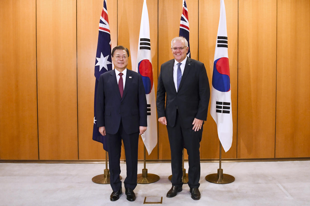 South Korean President Moon Jae-in, left, poses for a photo with Australian Prime Minister Scott Morrison at Parliament House, Canberra, Monday, Dec. 13, 2021. Moon is on a two-day official visit to Australia. (Lukas Coch/Pool Photo via AP)