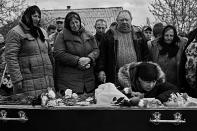 <p>Private Vasily Petrovich’s wife cries by the body of her husband while Vasily’s relatives mourn at the graveyard of Berestivets, a tiny village 200km from Kiev in Ukraine, April 2017. (Photo: Manu Brabo/MeMo) </p>