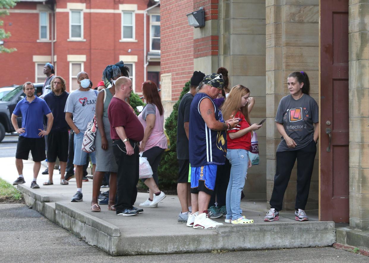 People wait in line for the Samaritan's Table at the Basilica of Saint John the Baptist's parish hall in Canton in this file photo. The program distributes free food to hundreds of people.