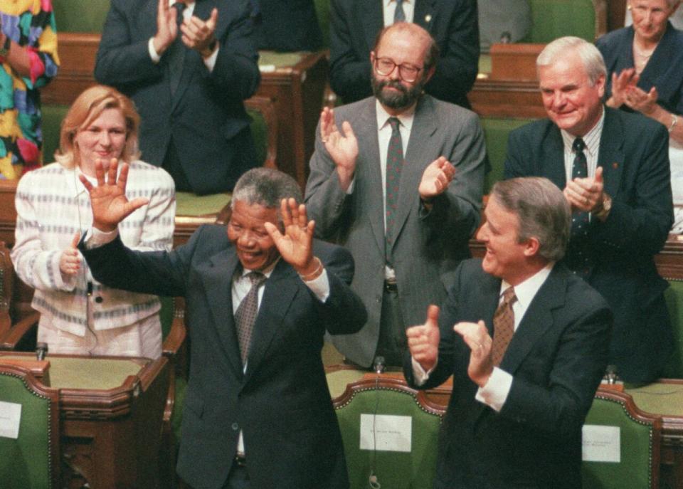 South African anti-apartheid activist Nelson Mandela raises his arms as he is acknowledged by the Prime Minister Brian Mulroney and other members of Parliament in Ottawa, June 18, 1990.South African's president says Mandela has died. 