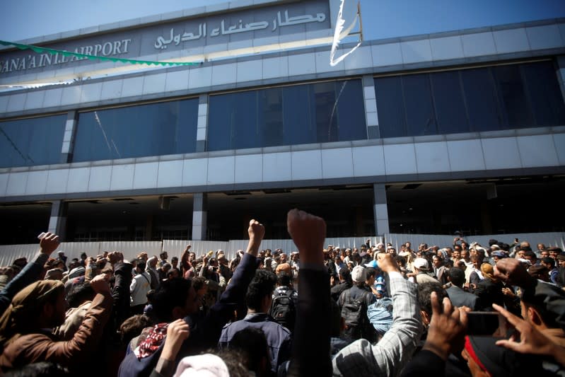 People react as they gather to greet Houthi detainees freed by the Saudi-led coalition upon their arrival at Sanaa airport in Sanaa, Yemen