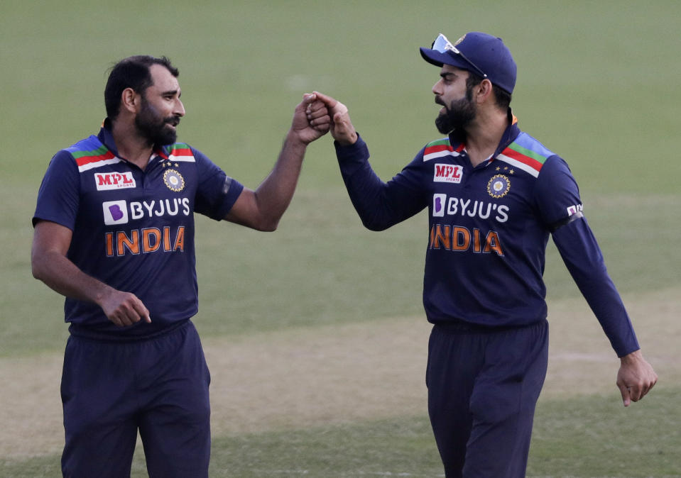 India's Virat Kohli, right, gestures with teammate Mohammed Shami during the one day international cricket match between India and Australia at the Sydney Cricket Ground in Sydney, Australia, Friday, Nov. 27, 2020. (AP Photo/Rick Rycroft)