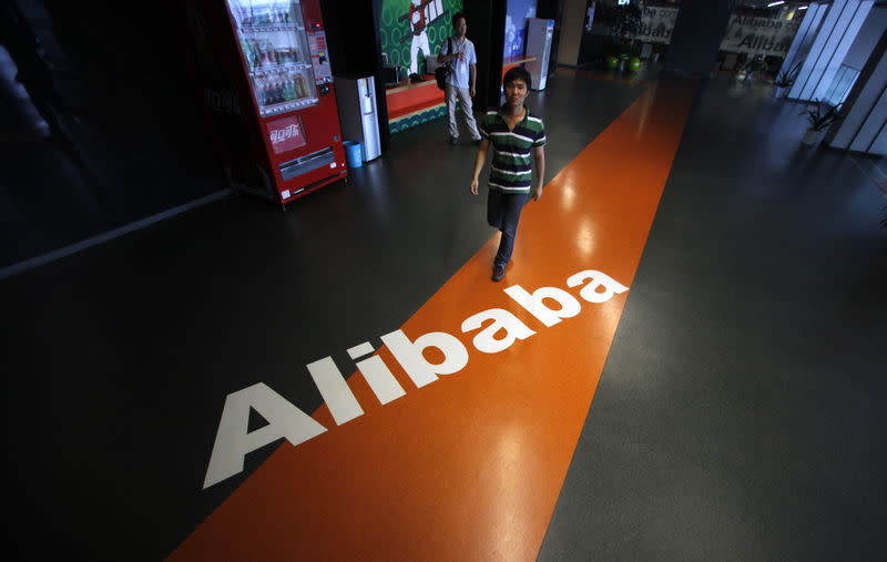 An employee walks pass a logo of Alibaba during a media tour organised by government officials at its headquarters on the outskirts of Hangzhou, Zhejiang province, June 20, 2012. REUTERS/Carlos Barria/Files