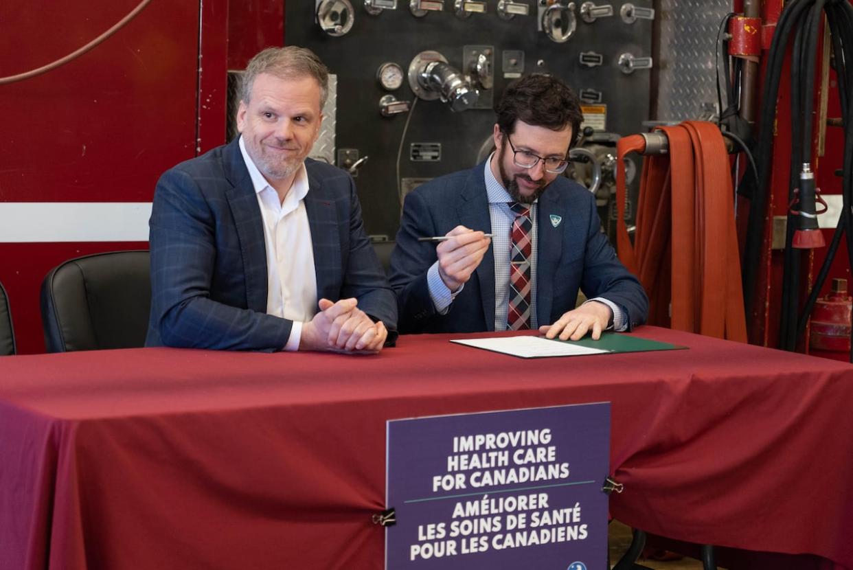 Federal Health Minister Mark Holland, left, and Nunavut Health Minister John Main signed health care funding agreements in Iqaluit on Tuesday. (David Gunn/CBC  - image credit)